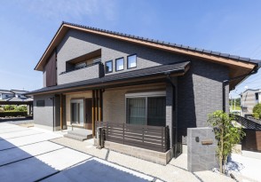大屋根が印象的な二世帯で暮らす外壁タイル張りの家